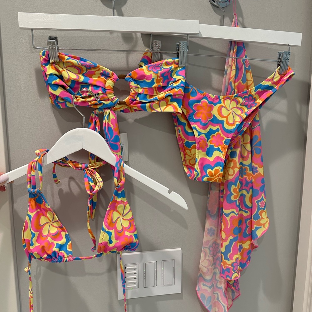 Includes 2 tops, high leg bottoms, and a wrap. Small tops. Medium bottoms.